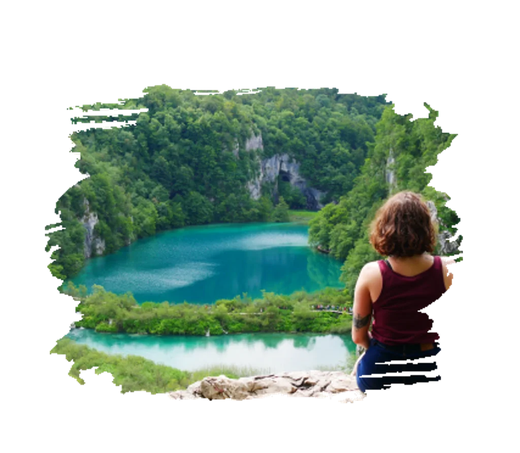 Femme assise sur un muret et contemplant un lac